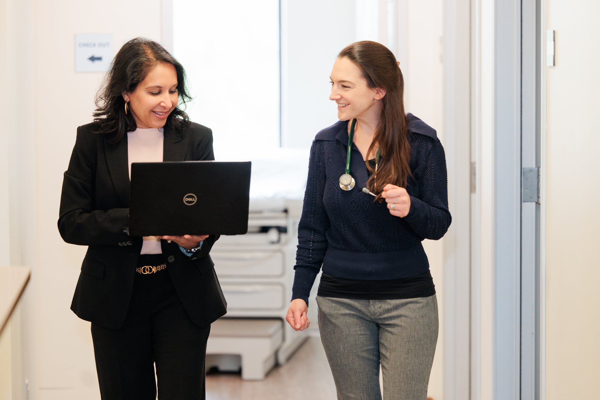 A physician and nurse having a conversation while walking