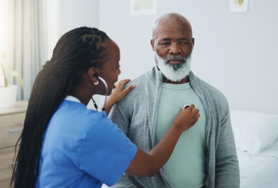 A physician listening to a patients heart beat