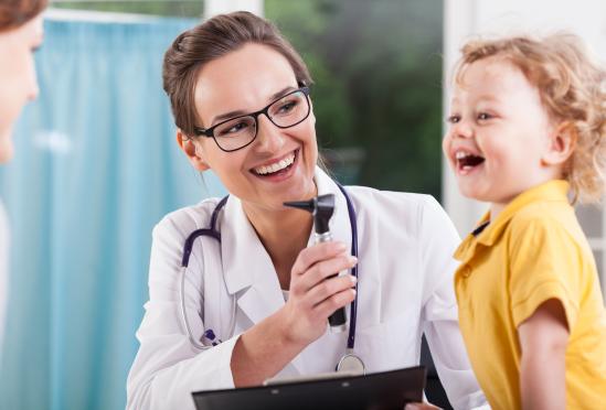 A physician working with a smiling child