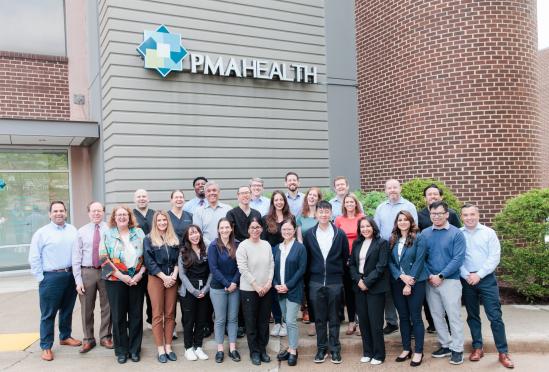 A group photo of the clinical staff in front of the building