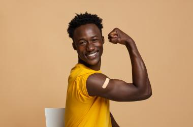 A patient flexing their arm after receiving a flu shot