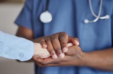 A physician holding a patients hand