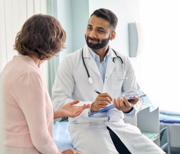 A provider taking notes with a patient