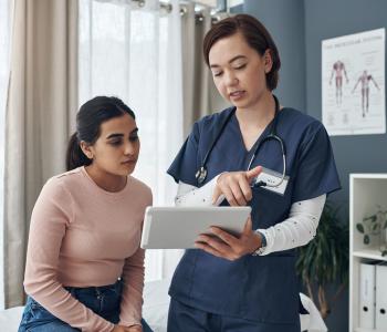 A patient and physician discussing paperwork