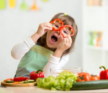 A child looking through two sliced peppers