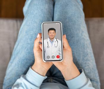 A woman using her phone for a telemedicine appoinrment