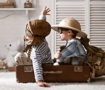 Two children playing in a suitcase