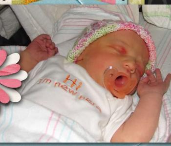 A sleeping newborn with a pacifier