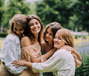 A group of smiling women embracing outside